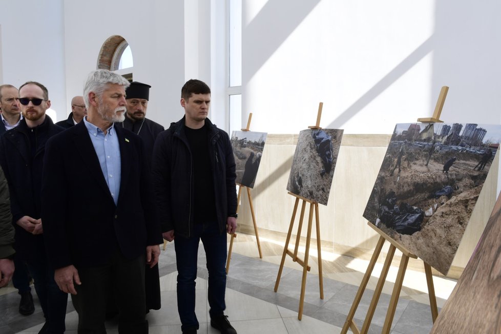 Petr Pavel si v kostele svatého Ondřeje v Buči prohlíží fotografie zachycující oběti ruské invaze.  (28.4.2023)