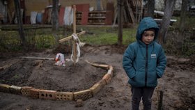 Šestiletý Vlad u hrobu své matky, kterou na předměstí Kyjeva pohřbili na dvorku.