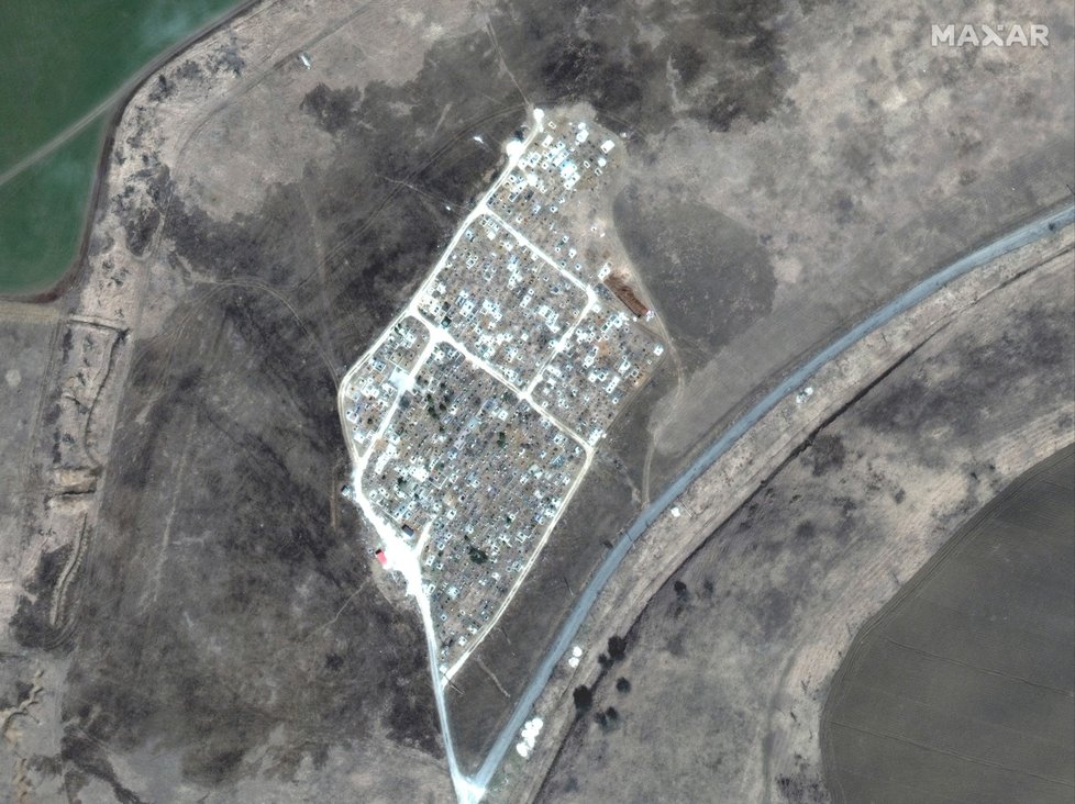 Přibývající hroby nedaleko Mariupolu na snímku z 29. března 2022