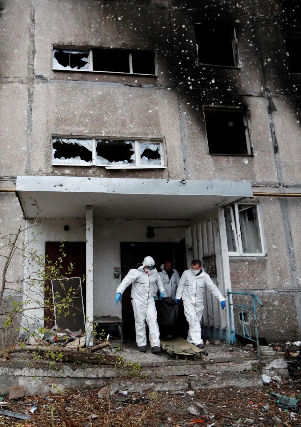Záchranáři v Mariupolu prohledávají domy a okolí a odnášejí oběti ruských útoků. (21.4.2022)