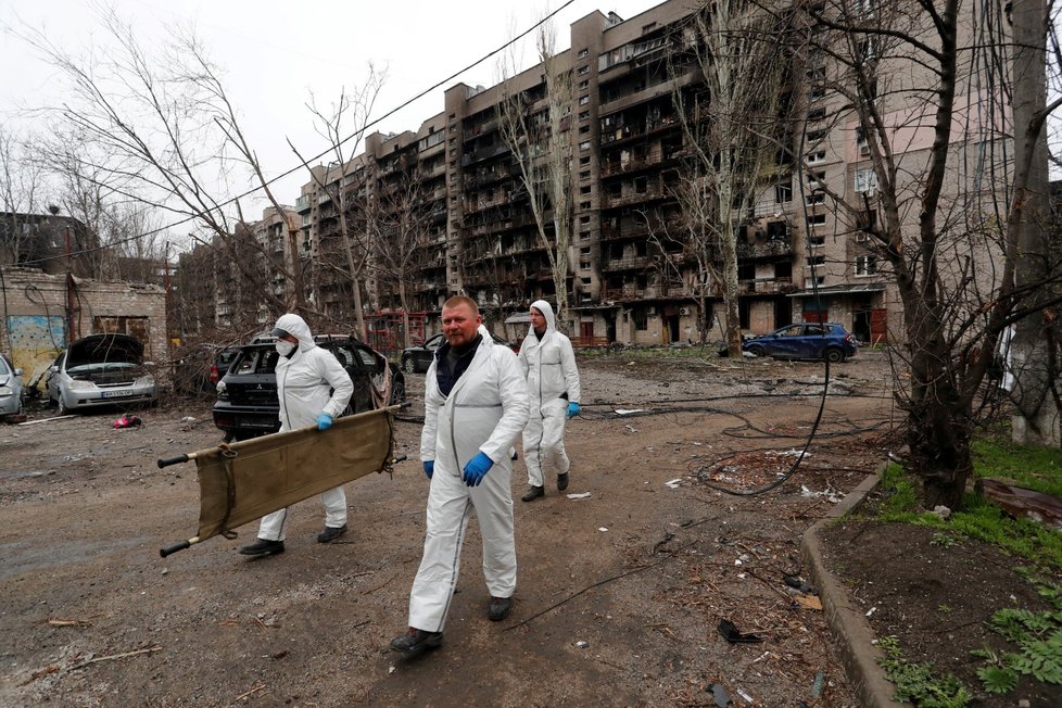 Záchranáři v Mariupolu prohledávají domy a okolí a odnášejí oběti ruských útoků. (21.4.2022)