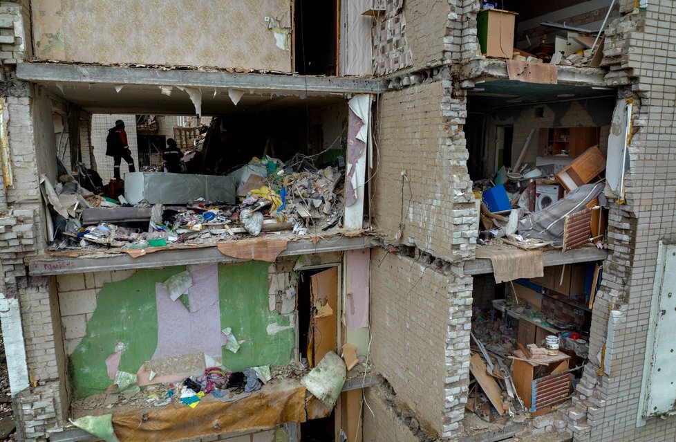 Hasiči prohledávají ruským ostřelováním poničený dům v Černihivu. (22.4.2022)