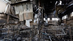 Spálená těla v poničeném vězení ve městě Olenivka.