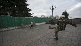 Ukrajinští vojáci hrají fotbal i s místními dětmi.