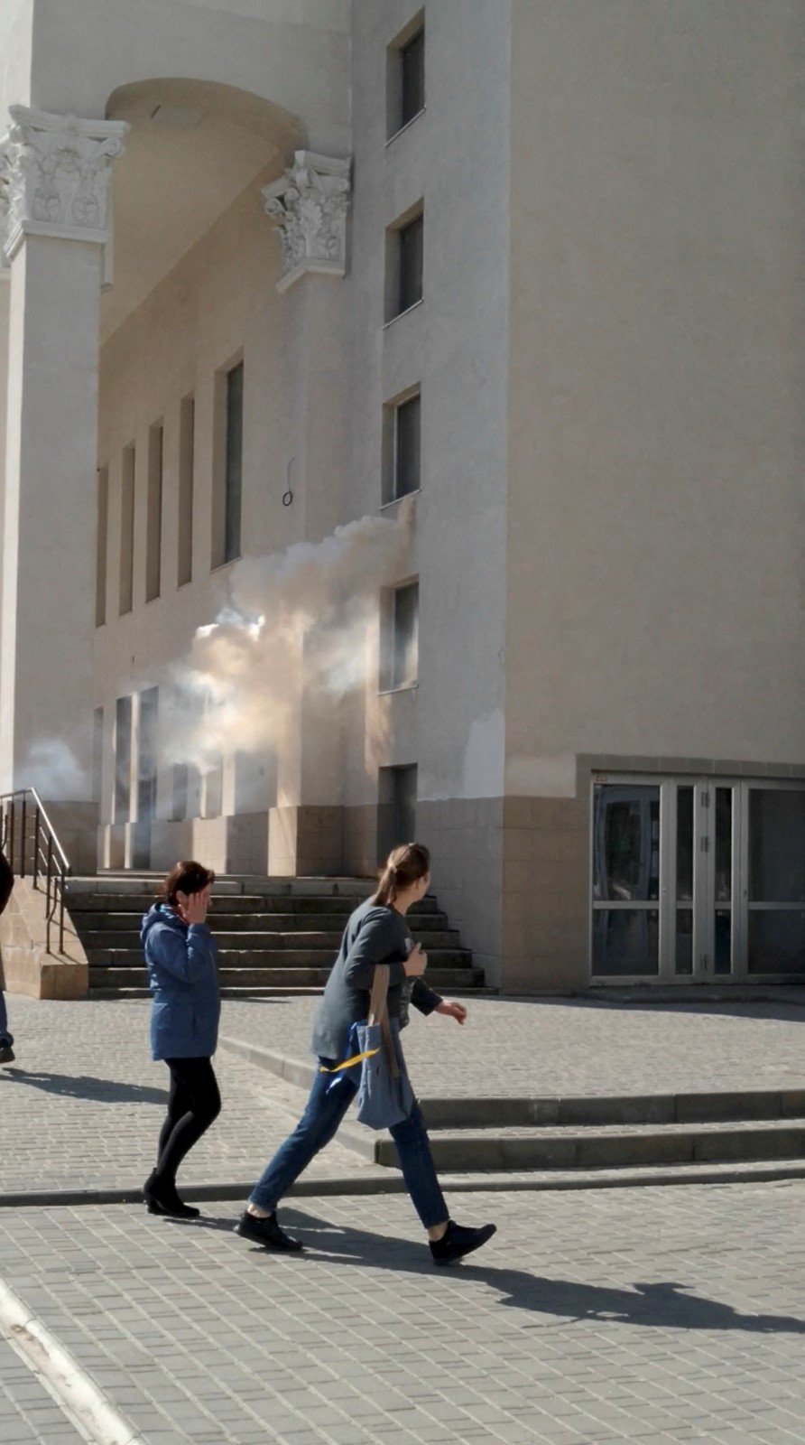 Lidé prchají před slzným plynem během protestu proti Rusům v Chersonu (27. 4. 2022)