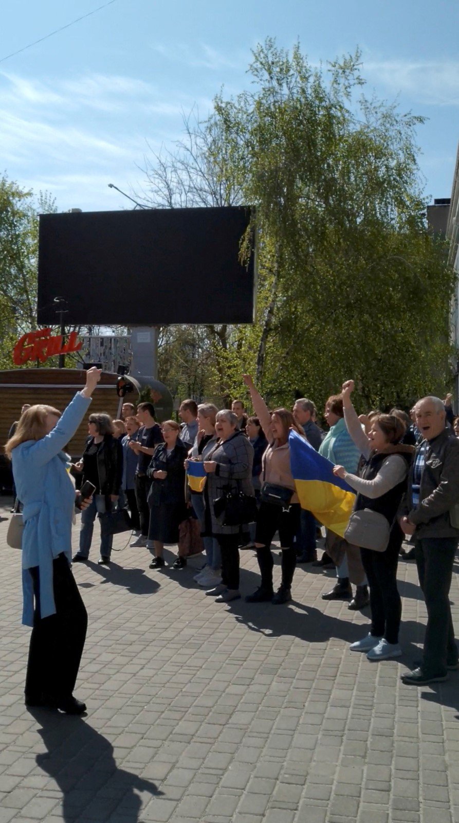 Lidé prchají před slzným plynem během protestu proti Rusům v Chersonu (27. 4. 2022)