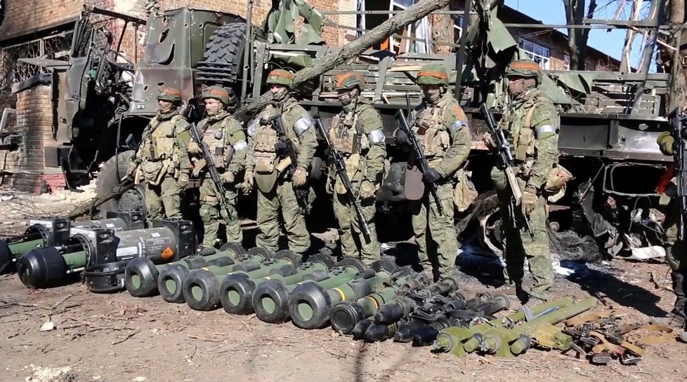 Ruští vojáci pózují u zbraní údajně získaných na Ukrajincích