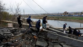 Obyvatelé v Bachmutu na Ukrajině překonávají řeku poté, co byl zničen most (30. 10. 2022).