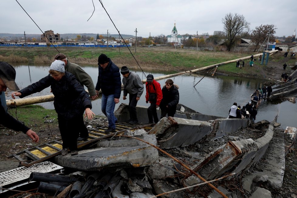 Obyvatelé v Bachmutu na Ukrajině překonávají řeku poté, co byl zničen most (30. 10. 2022).