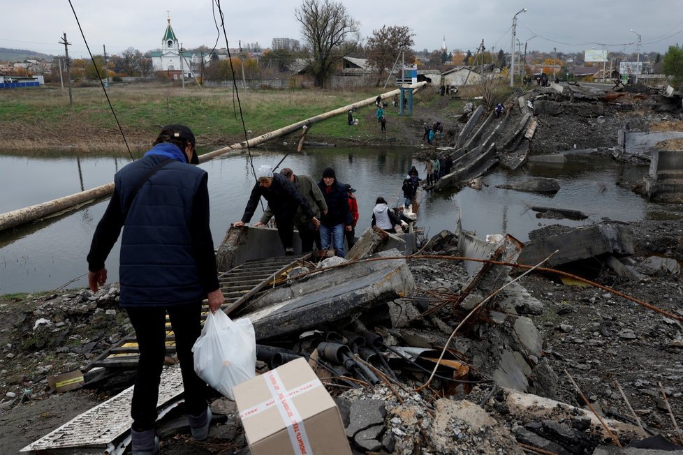 Obyvatelé v Bachmutu na Ukrajině překonávají řeku poté, co byl zničen most. (30. 10. 2022)