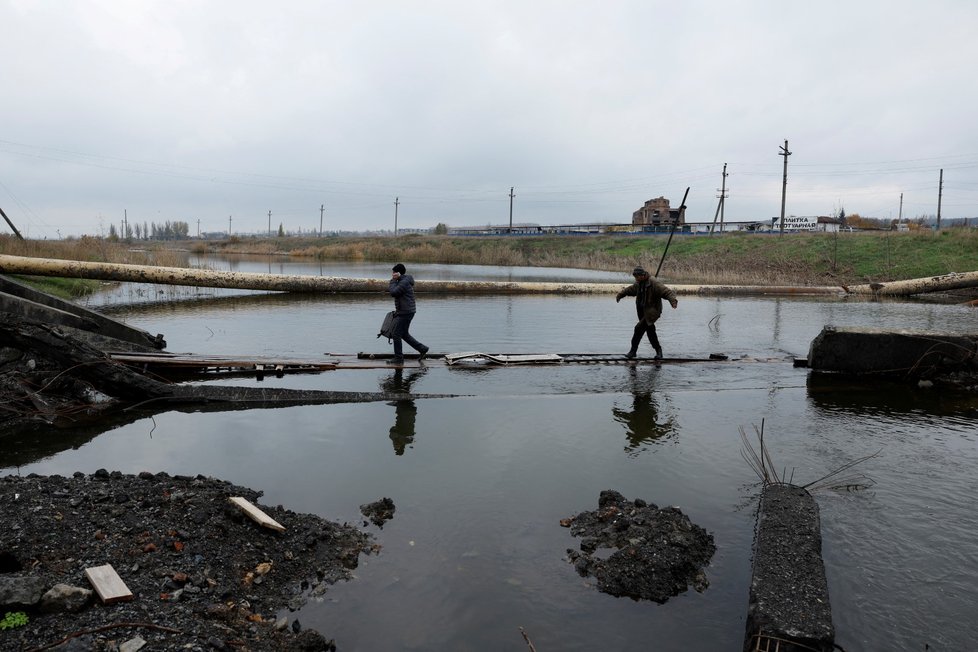 Obyvatelé v Bachmutu na Ukrajině překonávají řeku poté, co byl zničen most. (30. 10. 2022)