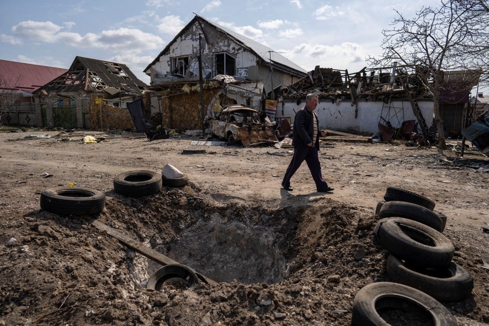 Válečná Ukrajina - kráter vytvořen bombou a poškozené domy po ruském bombardování Mykolajivu.,