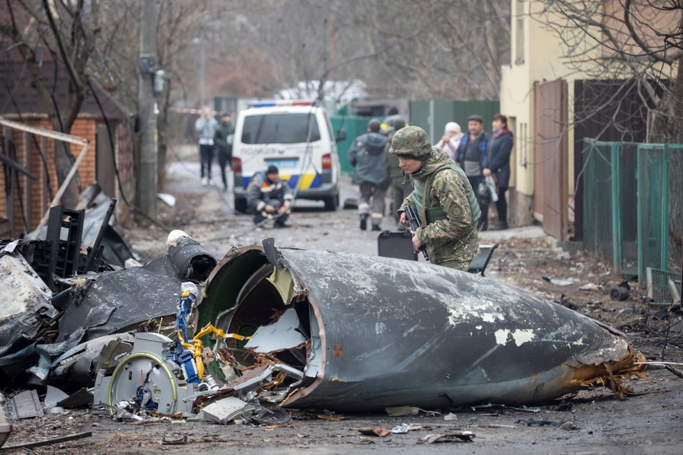 Voják ukrajinské armády si prohlíží fragmenty sestřeleného letadla v Kyjevě.