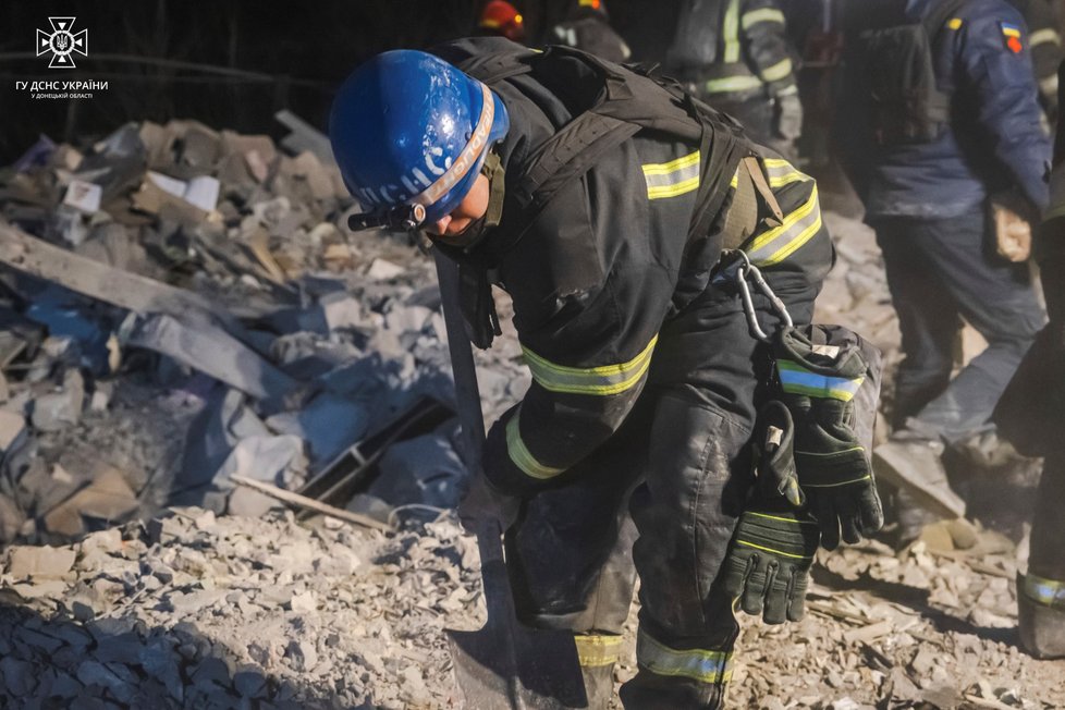 Na snímku poskytnutém ukrajinskou záchrannou službou odklízejí záchranáři trosky zničené budovy po ruském útoku v Pokrovsku v Doněcké oblasti na Ukrajině v sobotu 6. ledna 2024.