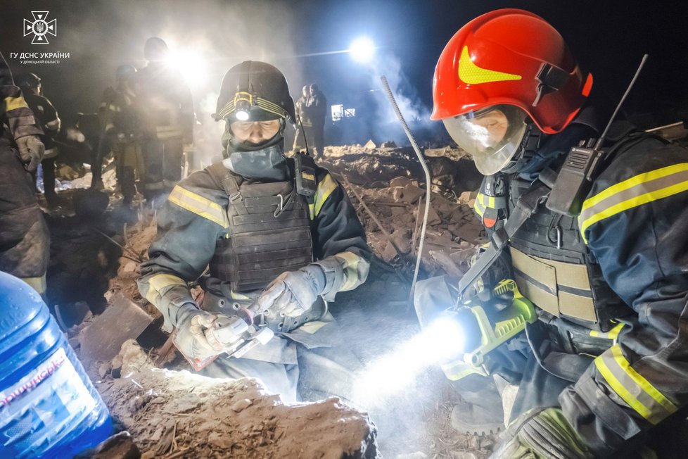 Na snímku poskytnutém ukrajinskou záchrannou službou odklízejí záchranáři trosky zničené budovy po ruském útoku v Pokrovsku v Doněcké oblasti na Ukrajině v sobotu 6. ledna 2024.