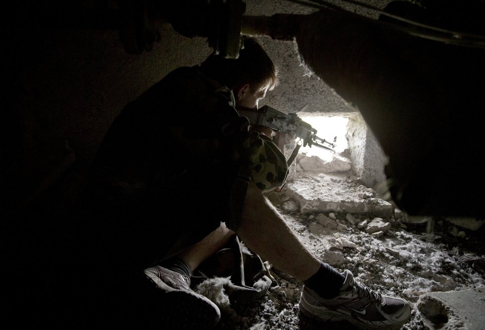 Ukrajinský separatista vyhlíží z díry vojáky.