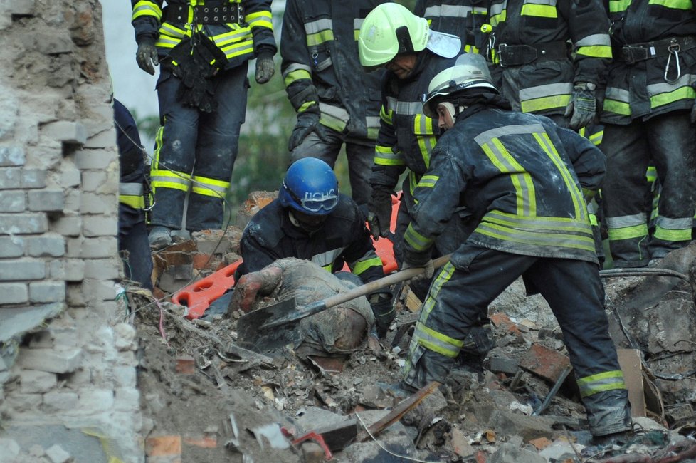 Záchranáři vytahují z trosek tělo muže, který zahynul při ruském raketovém útoku v Záporoží (11. října 2022)