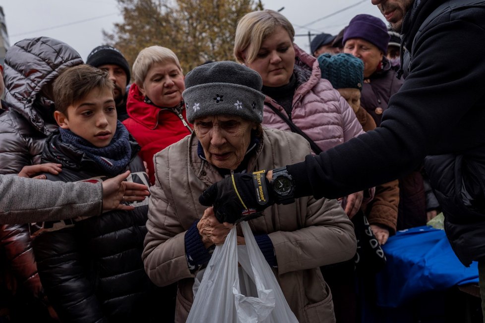 Lidé v Chersonu čekají na potravinovou pomoc. (17. 11. 2022)