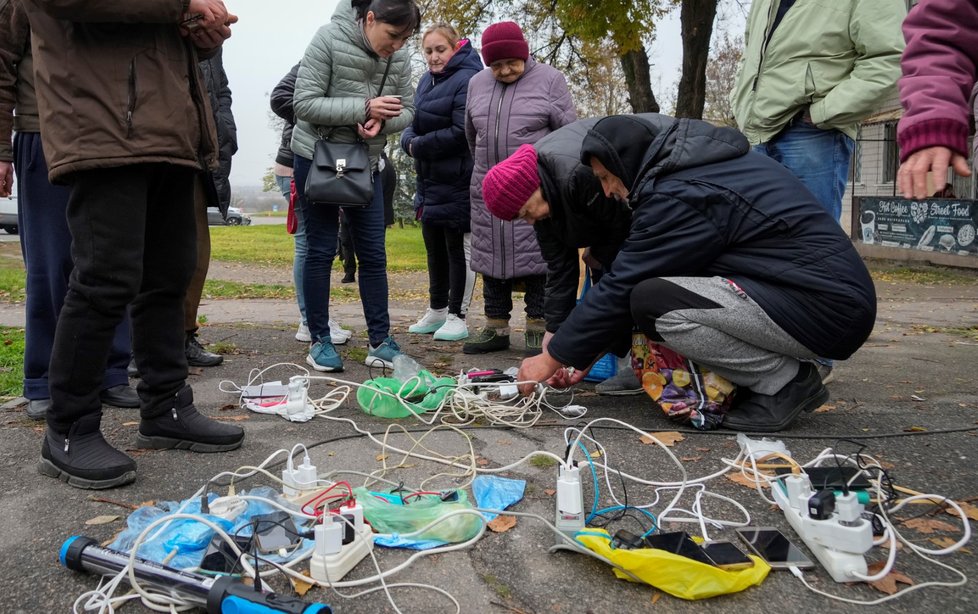 Lidé v Chersonu se snaží nabít mobilní telefony (17. 11. 2022)