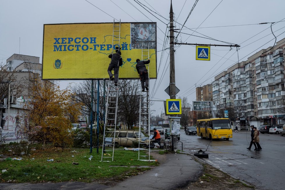 V osvobozeném Chersonu lidé strhávají ruské billboardy (2.12.2022).