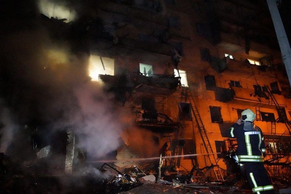 Hasiči pracují v poškozené obytné budově v ulici Koshytsa, předměstí ukrajinského hlavního města Kyjeva, které zasáhla vojenská střela.