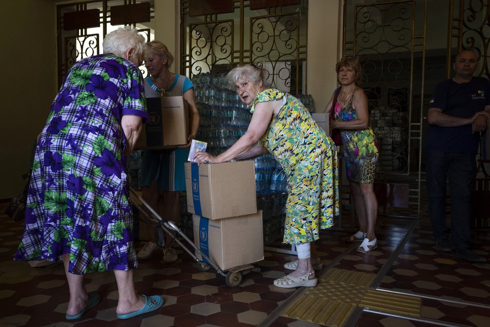 Lidé si vyzvedávají humanitární pomoc v Kramatorsku (7. 7. 2022)