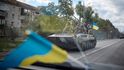 Ukrajinští vojáci jezdí na obrněném bojovém vozidle v nedávno osvobozeném městě Kupiansk.