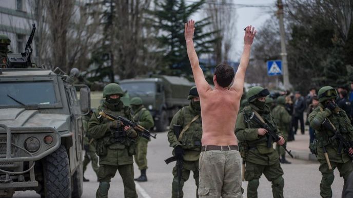 Ukrajinský muž stojí před vojáky ruské armády na předměstí Sevastopolu