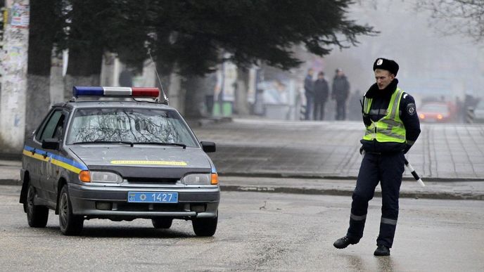 Ukrajinský policista hlídá budovu parlamentu ve Simferopolu