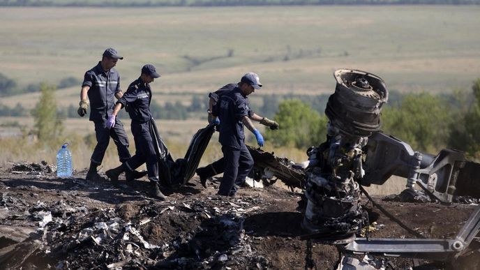 Ukrajinští záchranáři nesou tělo oběti leteckého neštěstí