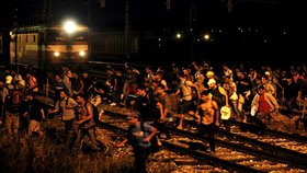 Běženci utíkají před vlakem.