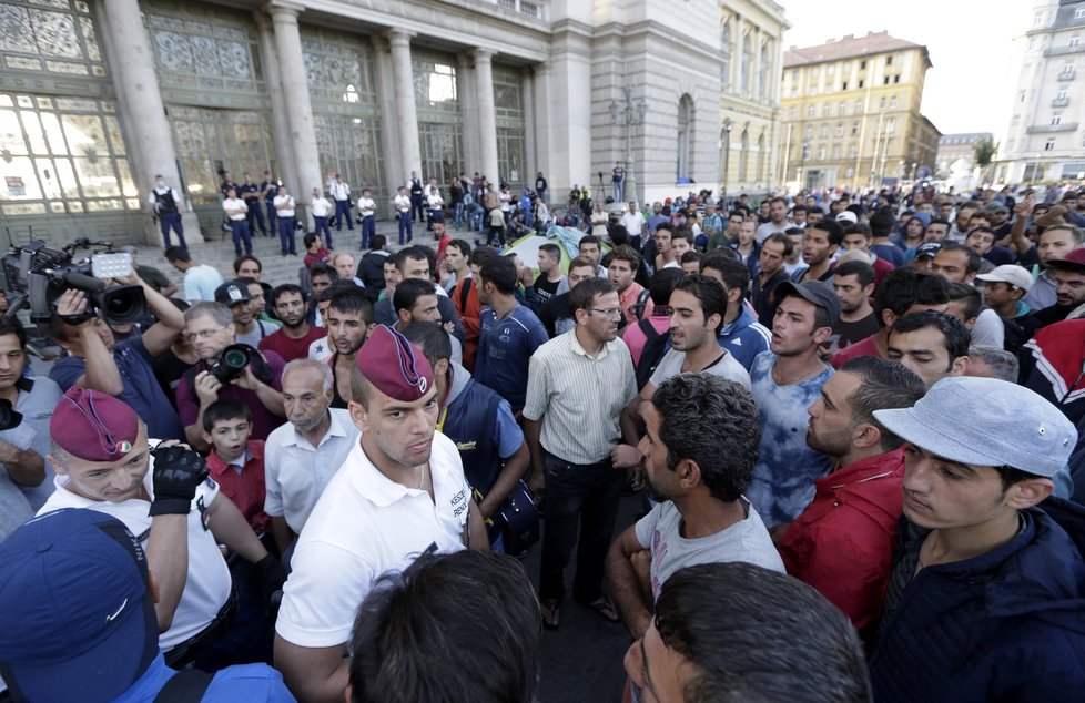 Policie uprchlíky vyzvala, aby opustili náměstí před nádražím a přesunuli se do určené tranzitní zóny.