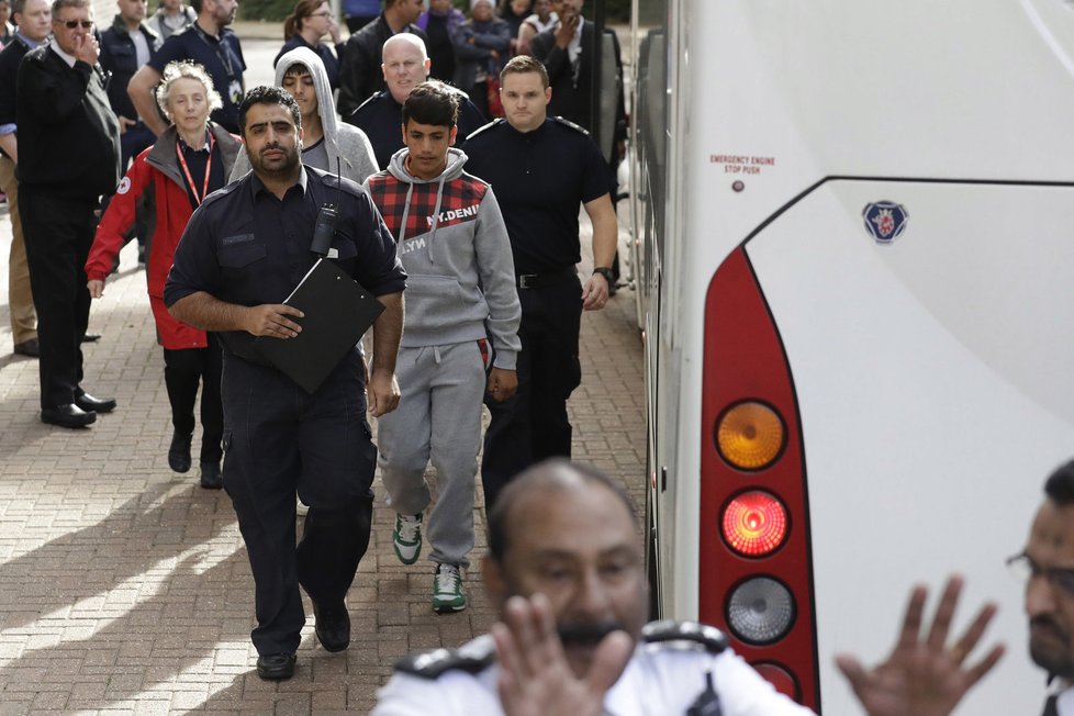 Britové eskortují skupinu mladistvých uprchlíků z tábora Calais ve Francii do imigračního centra v Londýně.