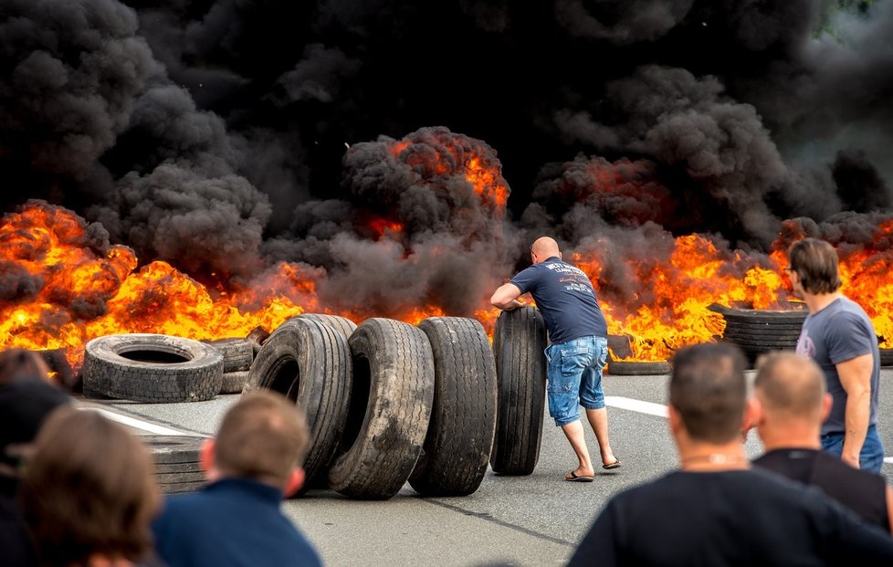 Stávkující zaměstnanci MyFerryLink podpalují pneumatiky.