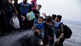 Afghánský muž s dítětem přijeli z Turecka na ostrov Lesbos.