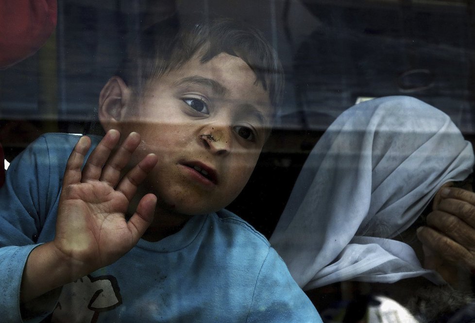 Uprchlíci ze Sýrie a Iráku v autobusu, který vyrazil z přístavu Pireus v Řecku.