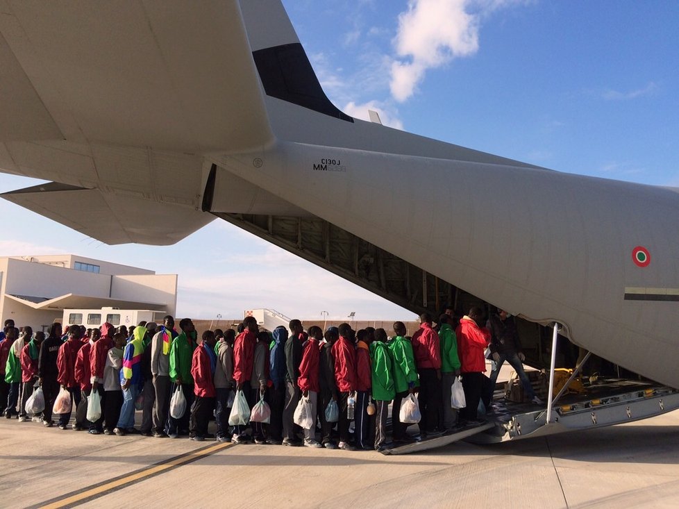 Běženci na italském ostrově Lampedusa při nástupu do letadla