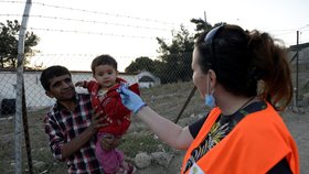Česká dobrovolnice Monika Pokorná, která pracuje na řeckém ostrově Lesbos, rozdává dětem sladkosti v uprchlickém táboře Moria. Tam čekají na registraci zhruba tři tisíce běženců různých národností. Nejčastěji z Afghánistánu a Iráku, ale také svobodní Syřané.