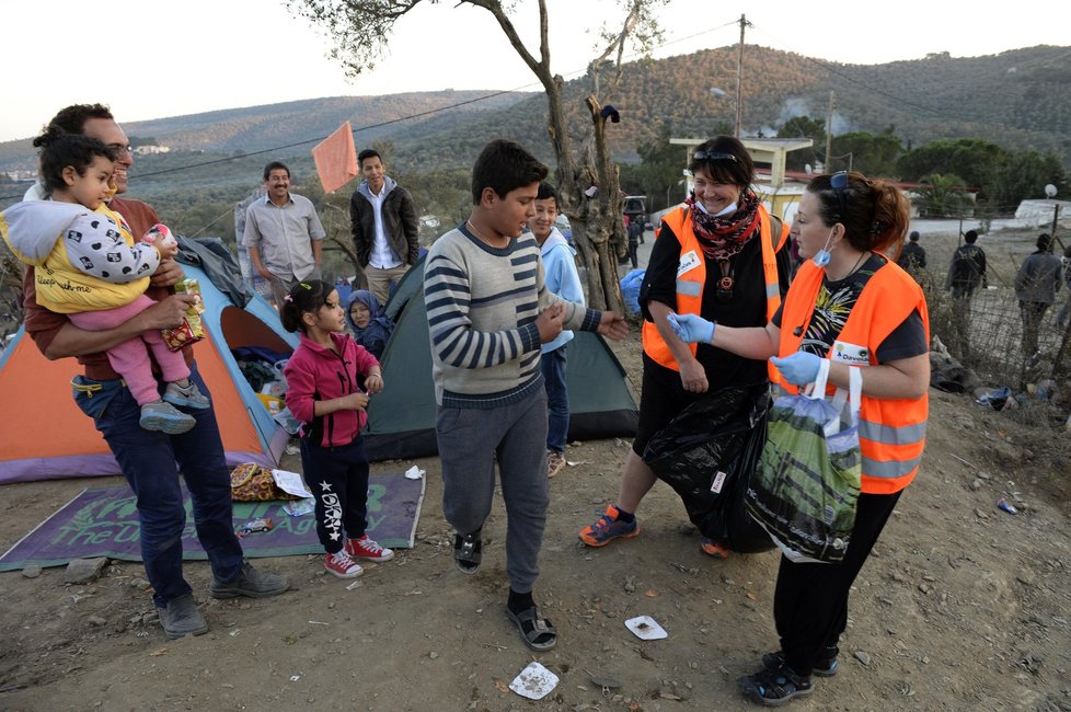 České doborovolnice Martina Janoušová a Monika Pokorná (vpravo), které pracují na řeckém ostrově Lesbos, rozdávají oblečení a dětem sladkosti v uprchlickém táboře Moria. Tam čekají na registraci zhruba tři tisíce běženců různých národností. Nejčastěji z Afghánistánu a Iráku, ale také svobodní Syřané.