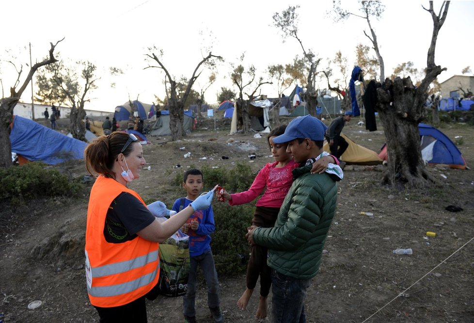 Česká dobrovolnice Monika Pokorná, která pracuje na řeckém ostrově Lesbos, rozdává oblečení a dětem sladkosti v uprchlickém táboře Moria. Tam čekají na registraci zhruba tři tisíce běženců různých národností. Nejčastěji z Afghánistánu a Iráku, ale také svobodní Syřané.