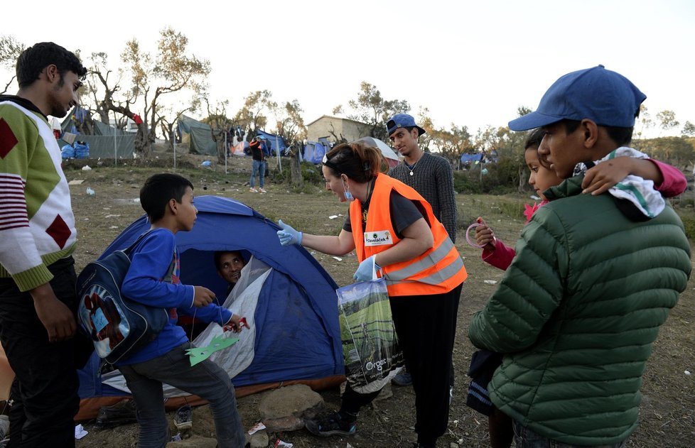 Česká dobrovolnice Monika Pokorná, která pracuje na řeckém ostrově Lesbos, rozdává oblečení a dětem sladkosti v uprchlickém táboře Moria. Tam čekají na registraci zhruba tři tisíce běženců různých národností. Nejčastěji z Afghánistánu a Iráku, ale také svobodní Syřané.