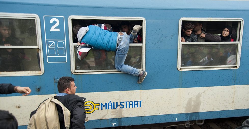 Uprchlíci naskakující do maďarského vlaku, mířícího na hranice s Rakouskem.