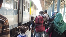 Rodina pospíchá na budapešťském nádraží Keleti k části vlaku, která je vyhrazená pro uprchlíky.
