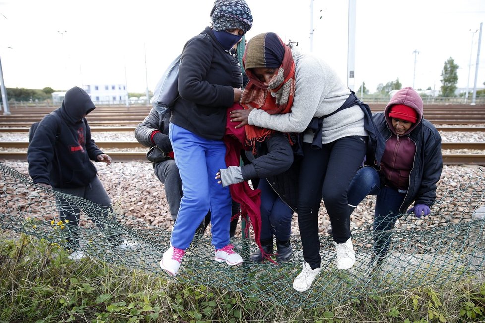 Uprchlíci přelézají plot a snaží se eurotunelem dostat do Velké Británie.