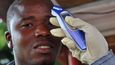 Úřednik měří teplotu muži předtím, než ho vpustí do obchodního centra v liberijské metropoli Monrovii. Libérie je jednou ze zemí nejvíce zasažených virem ebola