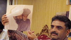 Pákistánský novinář Mazhar Ali Khan ukazuje fotku bin Ládina se synem Ibrahimem