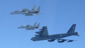 Na této fotografii poskytnuté japonským ministerstvem obrany jsou zachyceny stíhačky F-15 japonských vzdušných sil sebeobrany při společném vojenském cvičení s americkým bombardérem B-52 v blízkosti japonského vzdušného prostoru dne 10. prosince 2025.