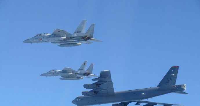 Na této fotografii poskytnuté japonským ministerstvem obrany jsou zachyceny stíhačky F-15 japonských vzdušných sil sebeobrany při společném vojenském cvičení s americkým bombardérem B-52 v blízkosti japonského vzdušného prostoru dne 10. prosince 2025.