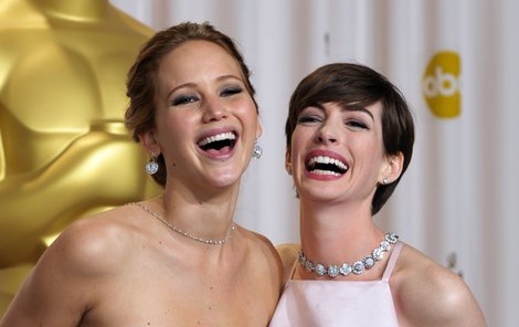 Tak která z vás je na řadě? Čerstvé držitelky Oscarů Jennifer Lawrence a Anne Hathaway (vpravo) se radují ze svých sošek. Anne je podle hollywoodské statistiky ohrožena rozvodem víc.