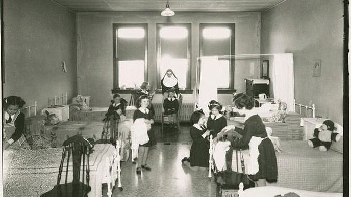 Fotografie zachycující jeptišku se svěřenkyněmi v bývalém sirotčinci.